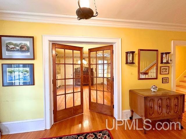 doorway featuring crown molding, french doors, and hardwood / wood-style flooring