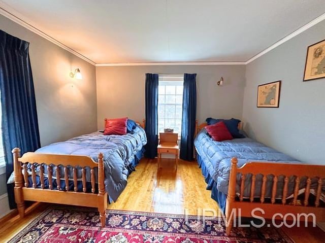 bedroom with wood-type flooring and crown molding