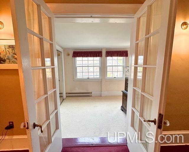 hall with carpet flooring, french doors, a baseboard radiator, and crown molding