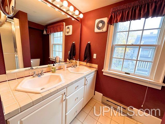 bathroom with toilet, vanity, tile patterned floors, and plenty of natural light