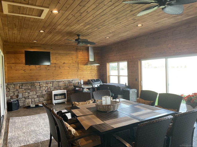 dining space featuring ceiling fan, wooden walls, heating unit, and wooden ceiling