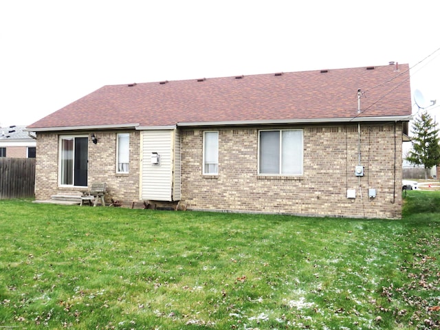 rear view of property with a yard