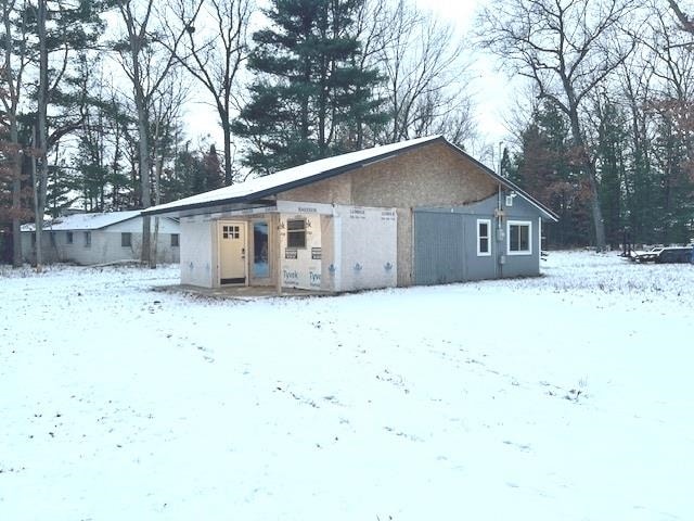 view of snow covered back of property