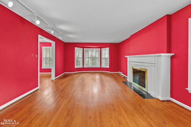 unfurnished living room with wood-type flooring and rail lighting