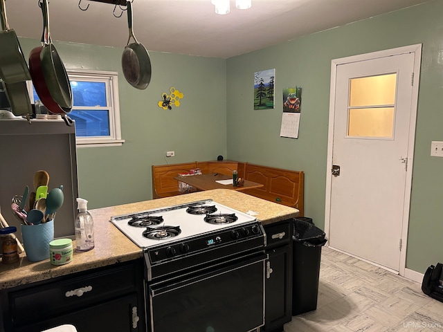 kitchen with light floors, dark cabinetry, and gas stove