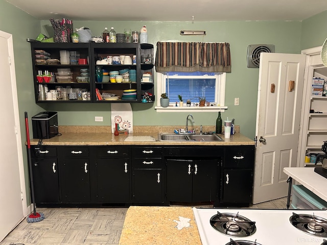 kitchen with light countertops, a sink, visible vents, and dark cabinets