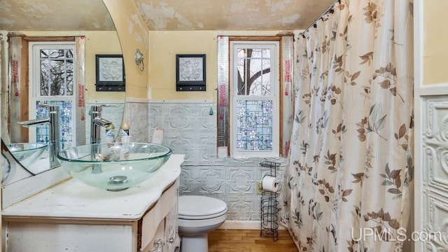 bathroom with vanity, a shower with shower curtain, toilet, tile walls, and wood-type flooring