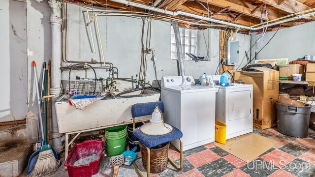 washroom with electric panel, sink, and independent washer and dryer