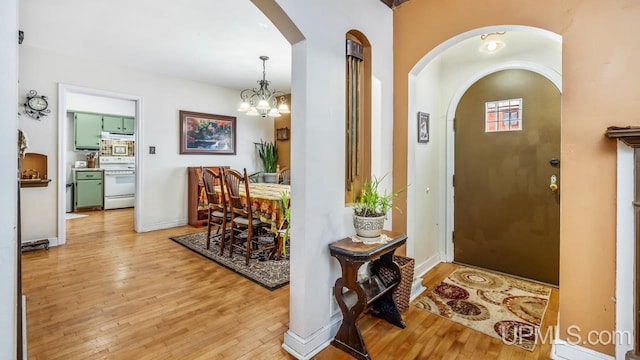 foyer entrance with a notable chandelier and light hardwood / wood-style flooring