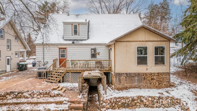 snow covered rear of property featuring a wooden deck