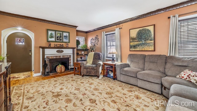 living room with hardwood / wood-style floors, a fireplace, crown molding, and a wealth of natural light