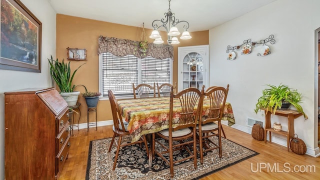 dining space with a notable chandelier and hardwood / wood-style flooring