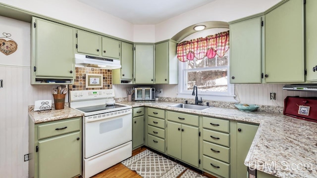 kitchen featuring light stone counters, electric stove, sink, light hardwood / wood-style floors, and green cabinets