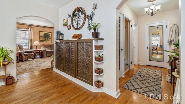 hallway featuring a chandelier and wood-type flooring