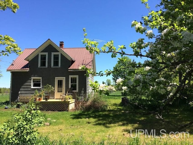 rear view of house with a lawn and a wooden deck