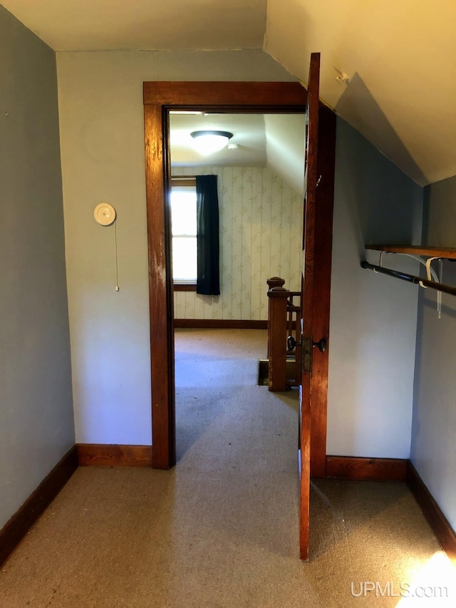 corridor featuring carpet flooring and vaulted ceiling