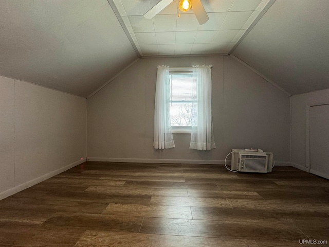 additional living space with a wall unit AC, lofted ceiling, ceiling fan, and dark hardwood / wood-style floors