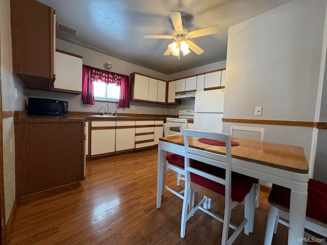 kitchen with white appliances, ceiling fan, sink, light hardwood / wood-style flooring, and white cabinetry