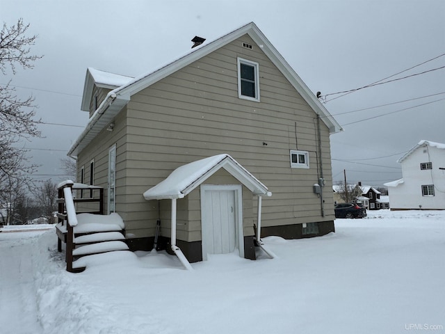 view of snow covered back of property