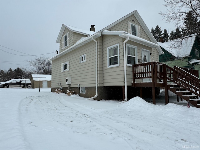 snow covered property featuring a wooden deck