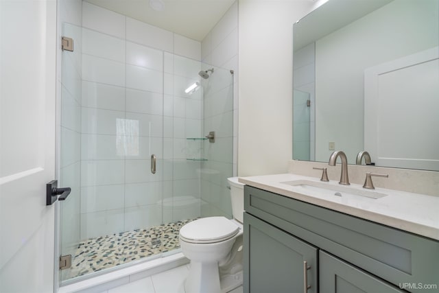 bathroom with tile patterned floors, vanity, toilet, and walk in shower