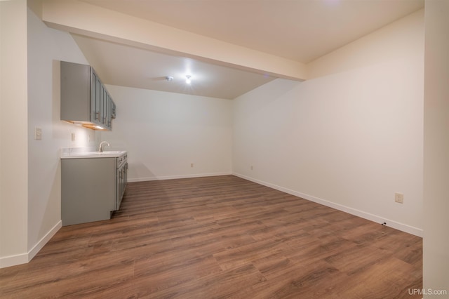 spare room with vaulted ceiling with beams, dark hardwood / wood-style floors, and sink