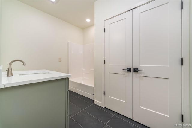 interior space featuring tile patterned flooring, vanity, and  shower combination