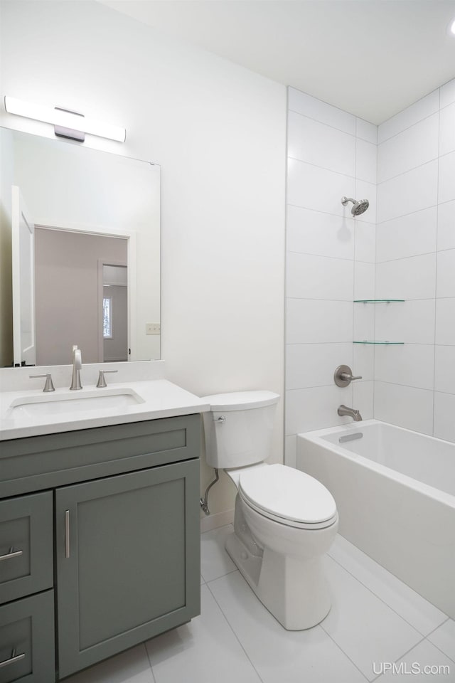 full bathroom featuring toilet, vanity, tiled shower / bath combo, and tile patterned floors