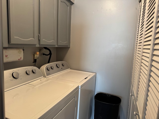 clothes washing area featuring washer and dryer and cabinets