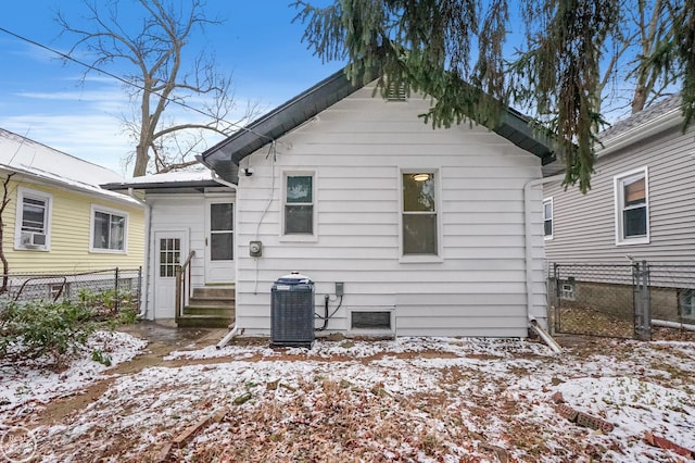 snow covered back of property with central air condition unit