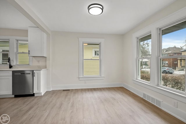 unfurnished dining area with light wood-type flooring and sink