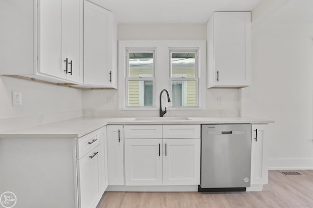 kitchen featuring white cabinets, dishwasher, and sink