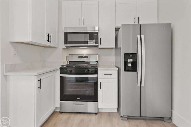 kitchen featuring white cabinetry, stainless steel appliances, and light wood-type flooring