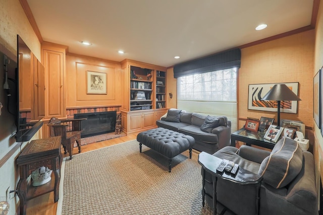 living room with light hardwood / wood-style floors, built in features, and crown molding