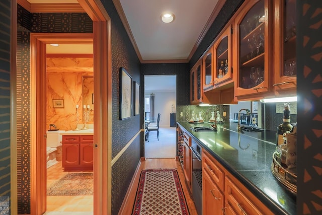 kitchen with crown molding, sink, and light hardwood / wood-style flooring