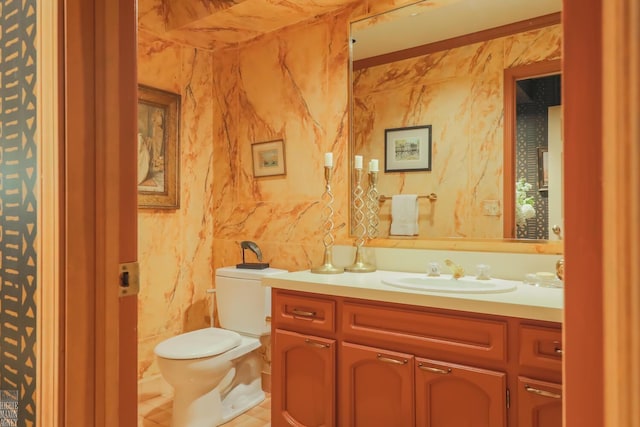 bathroom featuring vanity, tile walls, and toilet