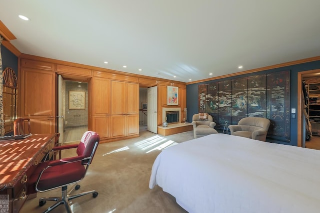 bedroom featuring a walk in closet, crown molding, and light colored carpet