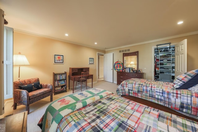 bedroom with a walk in closet, light colored carpet, a closet, and ornamental molding