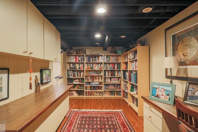 living area with beamed ceiling and light hardwood / wood-style flooring