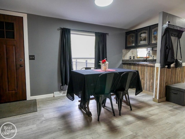 dining space with sink and light hardwood / wood-style floors