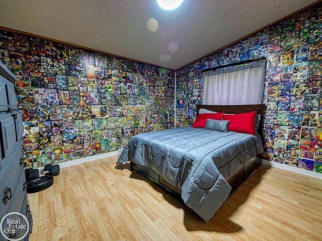 bedroom featuring ornamental molding, a textured ceiling, hardwood / wood-style flooring, and lofted ceiling