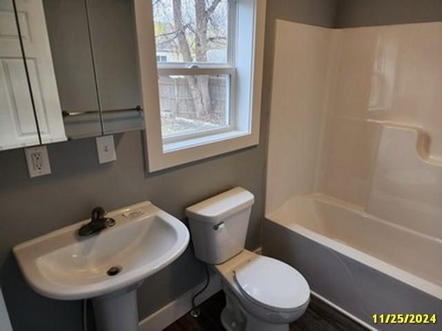 full bathroom featuring toilet, sink, and bathing tub / shower combination