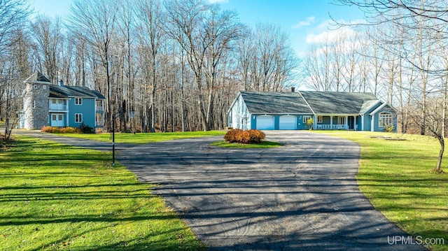 view of side of property with a porch, a yard, and a garage