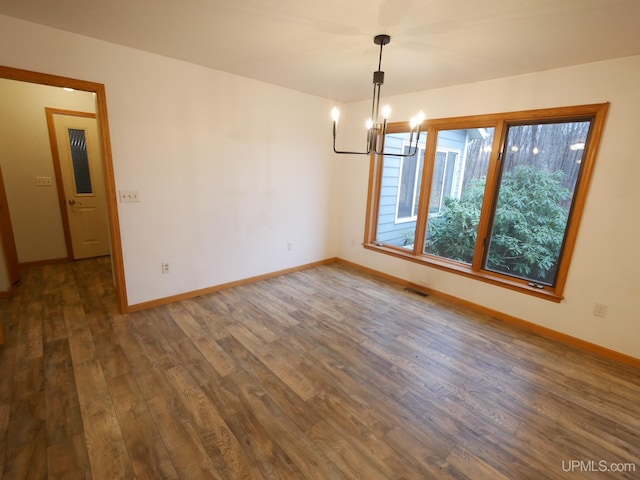 unfurnished dining area featuring dark hardwood / wood-style flooring and an inviting chandelier