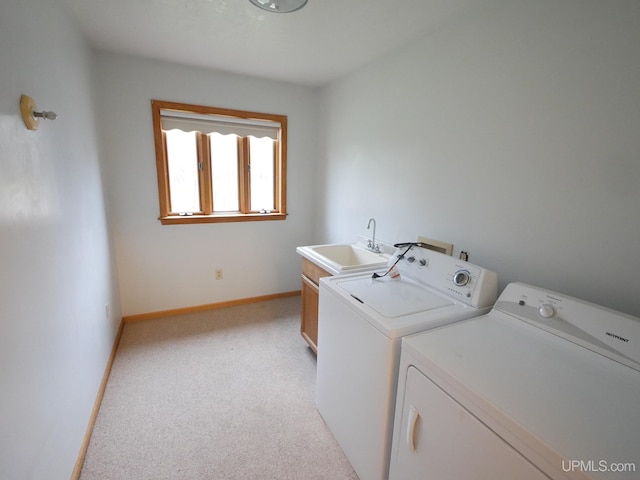 laundry area with washer and dryer, sink, light colored carpet, and cabinets