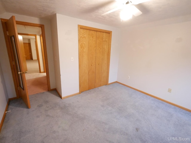 unfurnished bedroom with a closet, ceiling fan, and light colored carpet