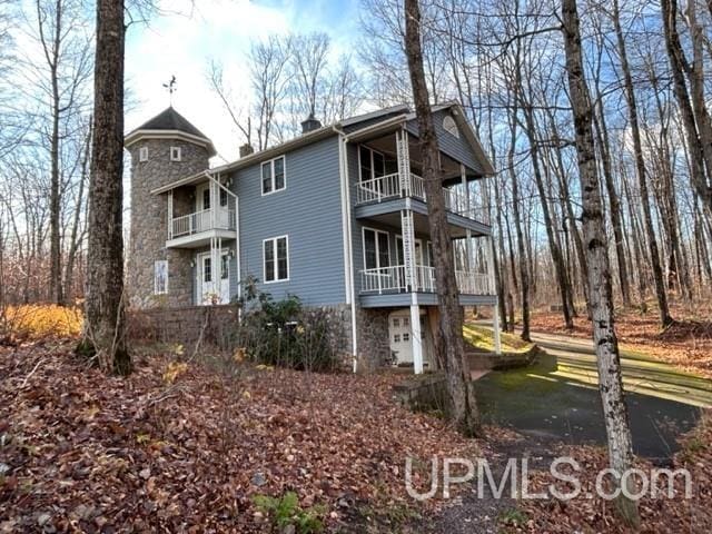 view of side of property with a balcony and a garage