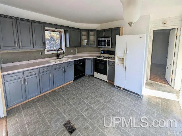 kitchen featuring white appliances, sink, and light hardwood / wood-style flooring