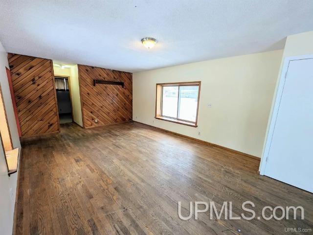 interior space featuring wood walls and dark hardwood / wood-style flooring