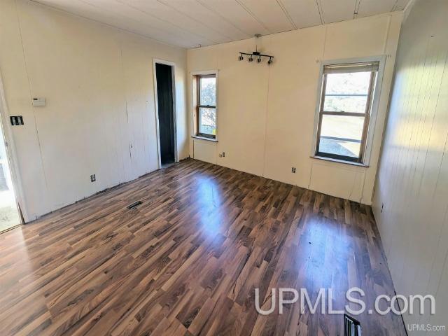 empty room with dark wood-type flooring